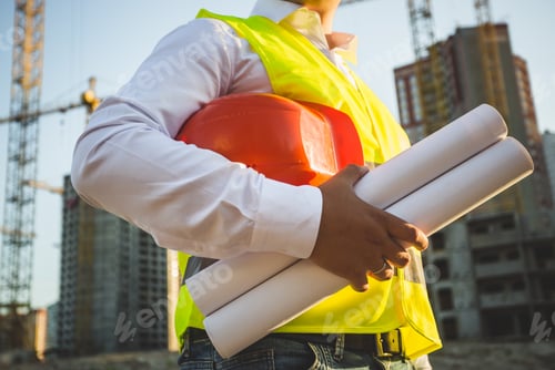 Preview: man in shirt and jacket holding hardhat and blueprints