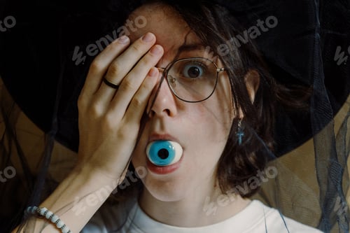 Preview: Teenager fooling around eating Halloween eye candy.