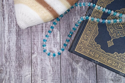 Preview: Holy book Quran and muslim prayer beads on table,