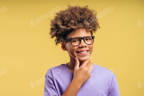 Preview: Handsome, smiling African American boy, pupil wearing stylish eyeglasses thinking looking at camera