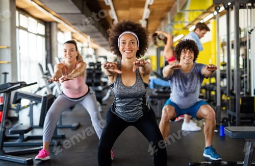 Preview: Multiethnic group of people training in a gym. Trainer and sportive fit persons exercising