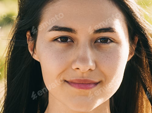 Preview: Portrait of young brunette woman posing in summerfield in white dress. Mountain background view.