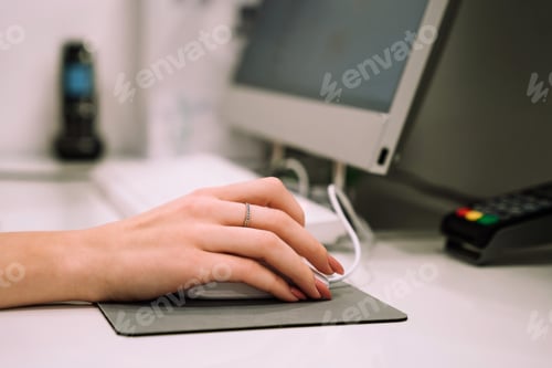 Preview: Close up hand of young woman administrator works at the reception of fitness club or health centre