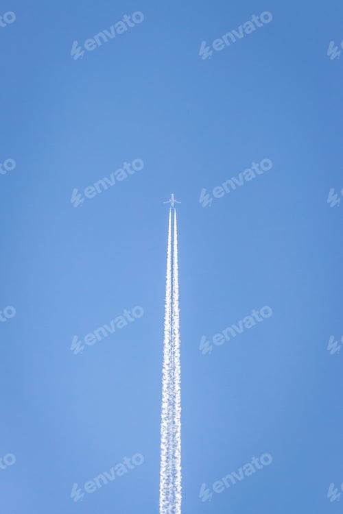 Preview: White plane soaring through a clear blue sky leaving behind a trail