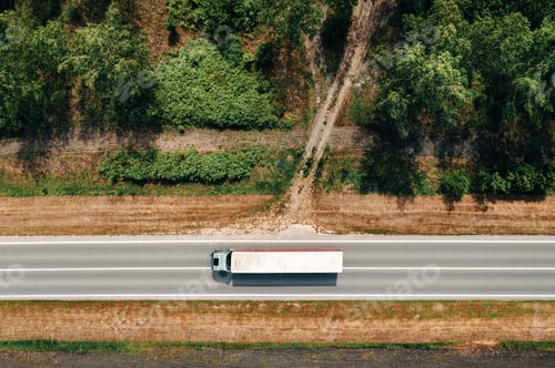Preview: Aerial shot of semi-truck driving along the highway through countryside landscape, drone pov