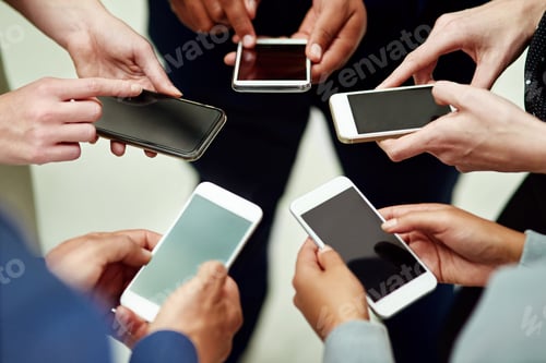 Preview: Cropped shot of a group of unidentifiable businesspeople using their smartphones in a huddle