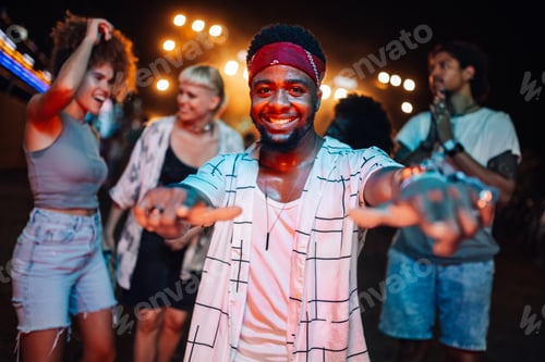 Preview: Young man enjoying music festival, dancing with friends at night