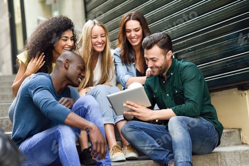 Preview: Multi-ethnic group of young people looking at a tablet computer