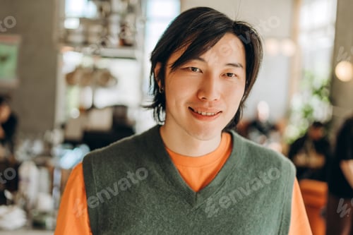 Preview: Young asian barista smiling in a coffee shop