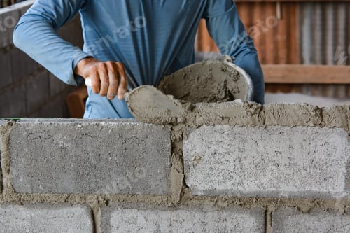 Preview: Bricklayer laying bricks on mortar