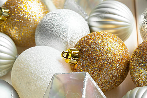 Vista previa: Christmas ornaments in gold and silver arranged on a wooden surface during the holiday season
