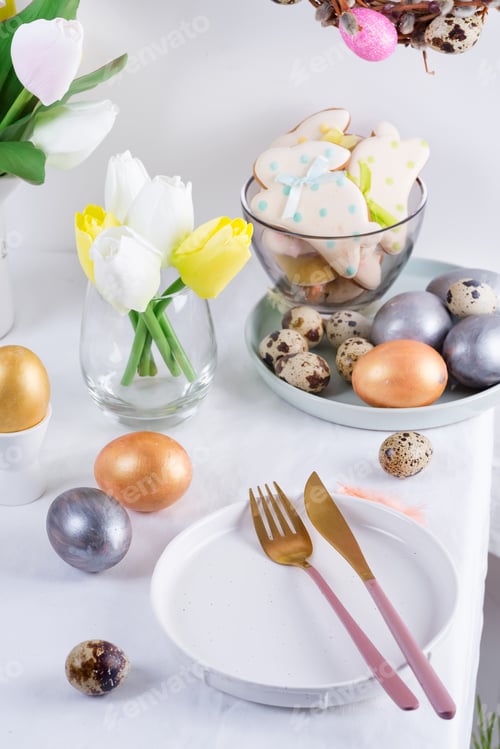 Preview: Holiday Easter table setting with craft painted eggs, baked cookies and fresh flowers on a table