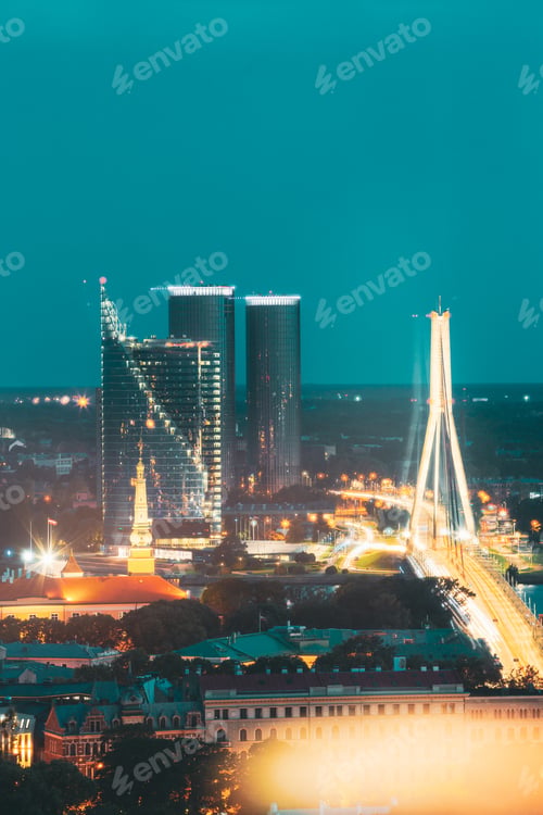 Preview: Riga, Latvia. Aerial View Of Night Cityscape In Evening Night Lights Illumination. Vansu Cable