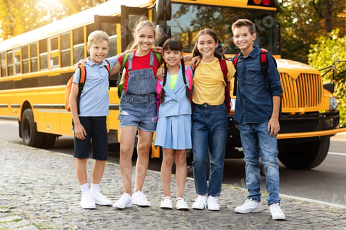 Preview: Cheerful kids with backpacks standing by yellow school bus, smiling and embracing