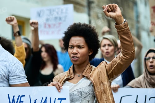 Preview: African American woman with raised fist participating in a protest for human rights.