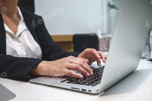 Preview: Businesswoman typing on laptop in workspace