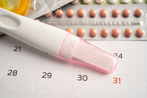 Preview: Pregnancy test and birth control pills on calendar, contraception health and medicine.