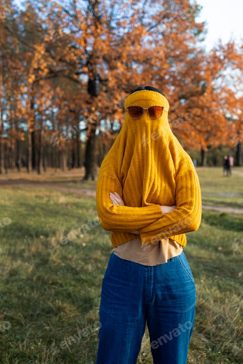 Preview: autumn outdoor portrait of funny happy girl walking in park or forest in warm yellow sweater and sun