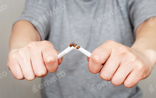 Preview: young woman holding broken cigarette in her hands close