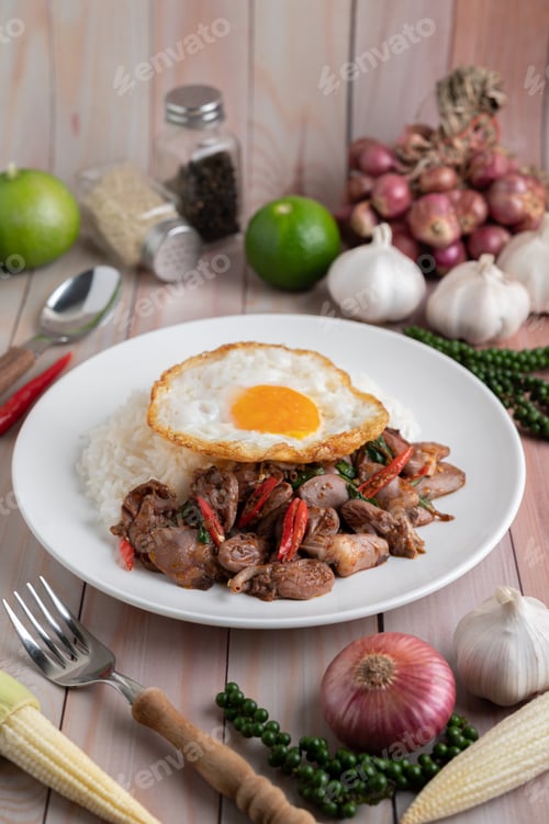 Preview: Holy Basil Fried Rice with Chicken Heart and Fried Egg on a White Wooden Floor.