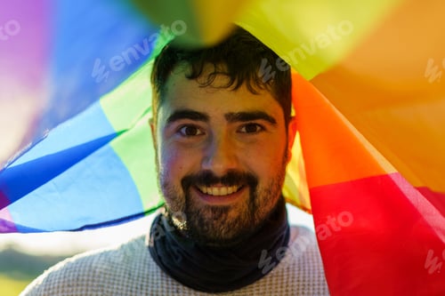 Preview: Man smiling under the LGBT flag