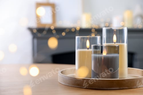 Preview: Decorative LED candles on wooden table at home, space for text. Bokeh effect