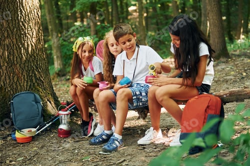Preview: Taking a break. Kids strolling in the forest with travel equipment