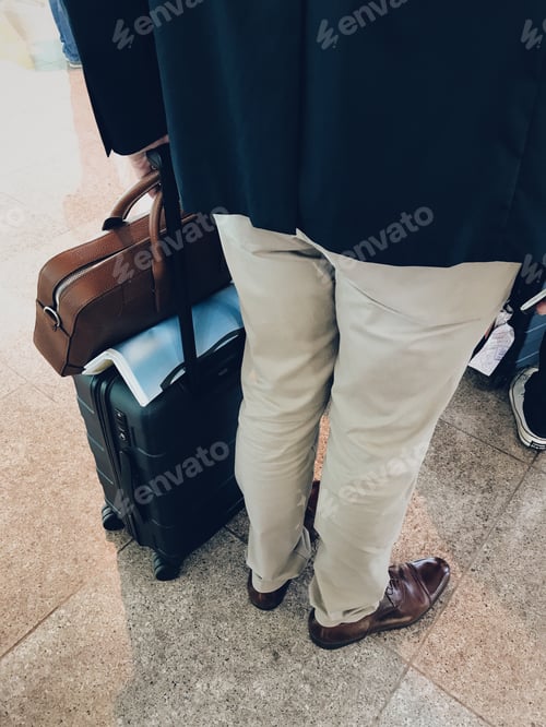 Preview: Man standing in line at the airport with carry-on bags #debb_a/travel