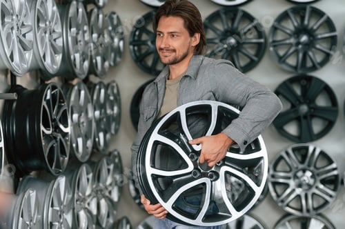 Preview: Disk in hands. Man is in the tire fitting car service