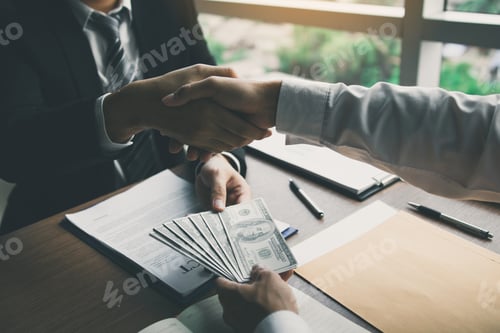 Preview: Business Handshake with Money Exchanged in Office