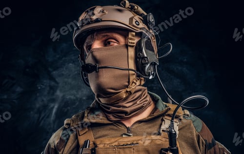 Preview: Close-up portrait. Private security service contractor in camouflage helmet with walkie-talkie.