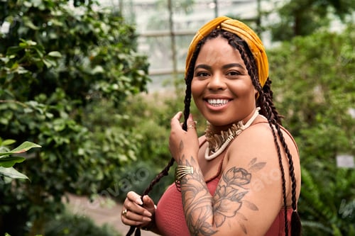 Preview: Lively moments in a greenhouse with a joyful African American woman wearing braids