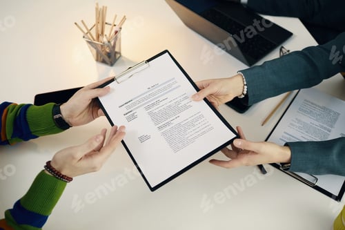 Preview: Employee Giving His CV To Manager At Interview
