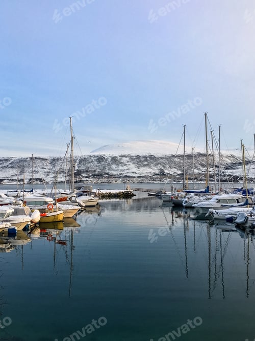 Vorschau: Boote und Segelboote legten im Winter in der Marina an. Schnee, kaltes Wetter, Meer. Tromsø, Norwegen.