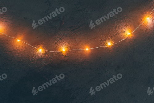 Preview: Warm light illuminated garland close up on dark background