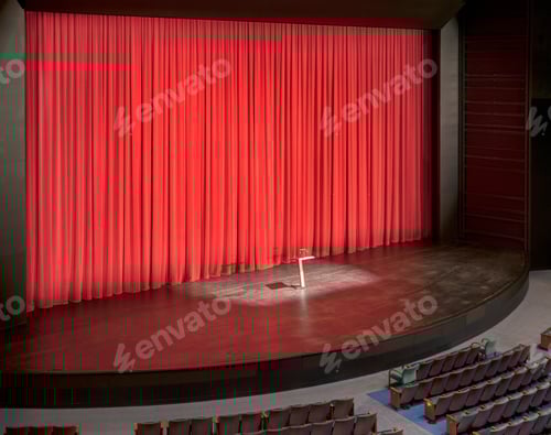 Preview: Stage with red curtains in an empty auditorium.