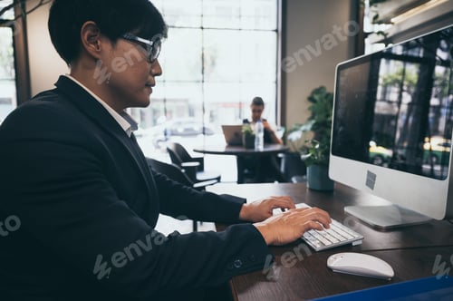 Preview: confident professional businessman working with laptop in modern business office