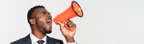 Preview: african american businessman in suit screaming in megaphone isolated on grey, banner