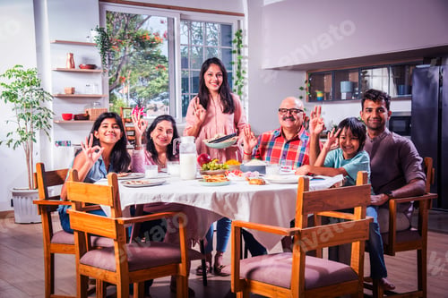 Preview: Indian family having lunch at home on dining table with grandparents, parents and kids