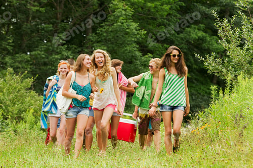 Preview: Teenagers carrying a hamper in the countryside