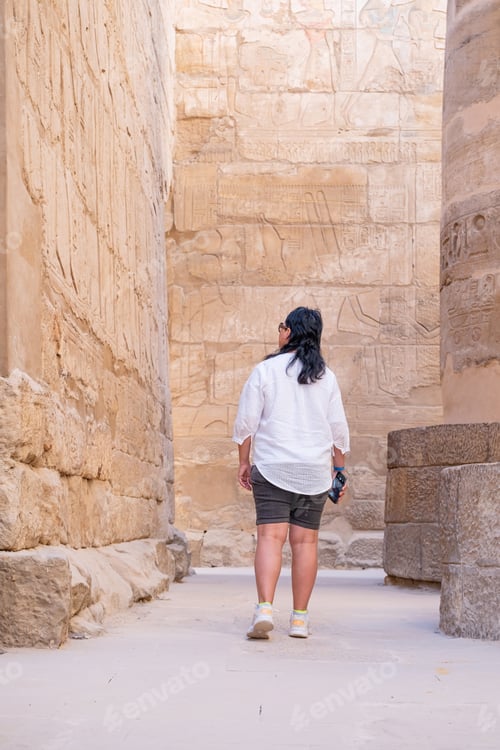 Preview: Woman traveler explores the ruins of the ancient Karnak temple in the city of Luxor in Egypt.