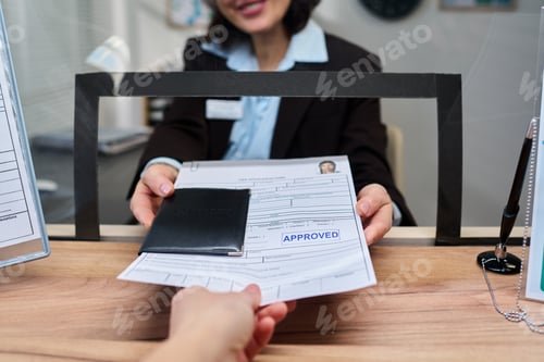 Preview: Woman Handing Approved Visa Documents to Young Adult at Visa Center