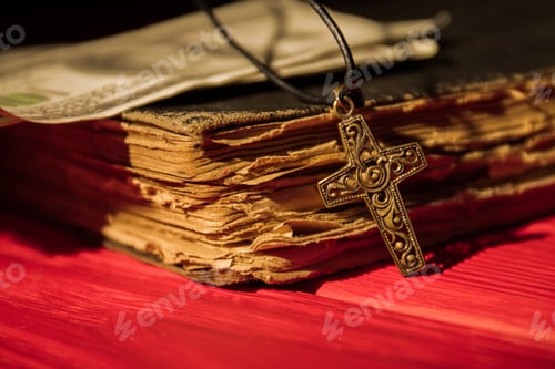 Preview: Ornamented decorative golden cross and old book close-up.