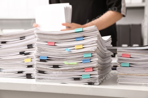Preview: Stacks of documents with paper clips on office desk
