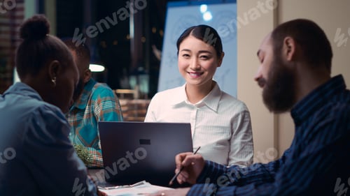 Preview: Smiling asian employee looking at camera in business meeting