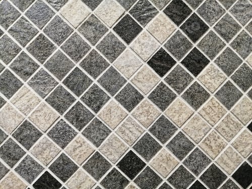 Preview: Closeup of a wall covered in small gray and beige mosaic tiles