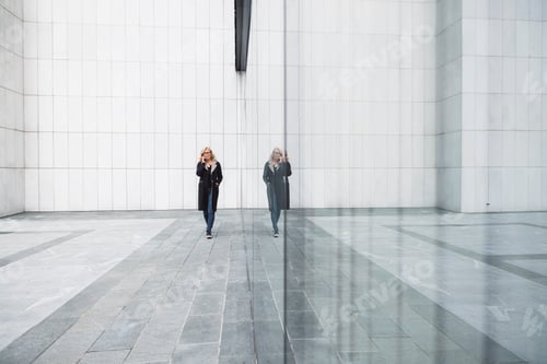 Preview: A female leader walks in front of an office building in cloudy weather. She meets a male businessman