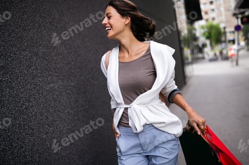 Preview: Portrait of young happy smiling woman with shopping bags