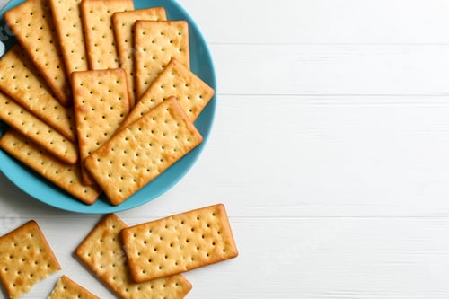 Preview: Delicious crackers on white wooden table, flat lay. Space for text