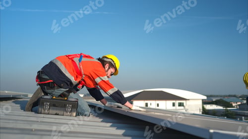 Preview: Both of technicians is installing solar panels on the roof of the warehouse